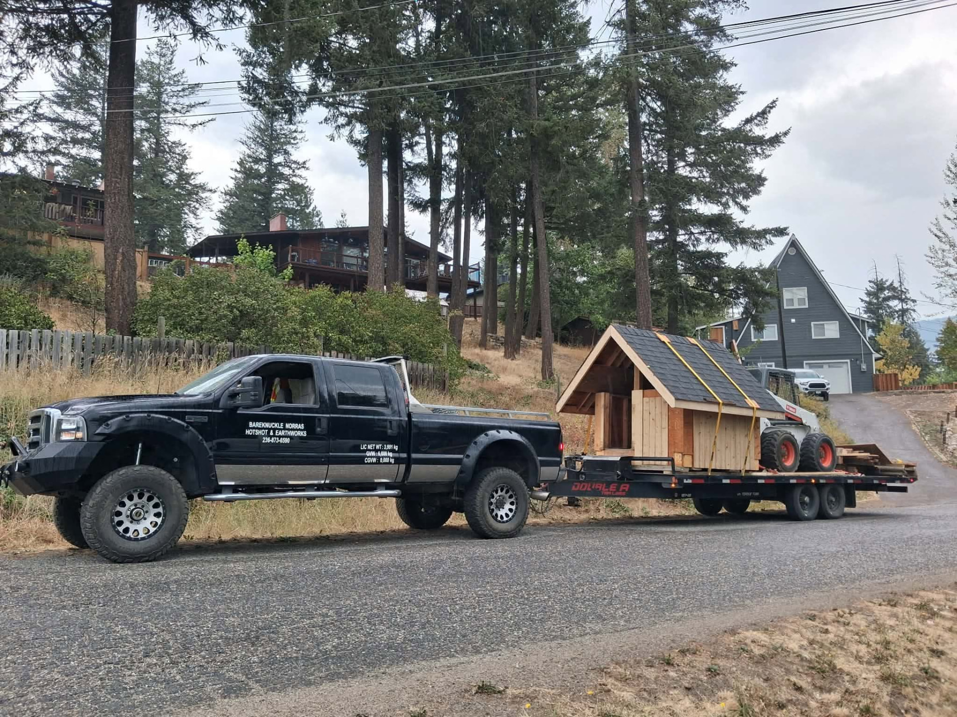 Bradley’s truck and trailer transporting a wooden playhouse in Lumby.
