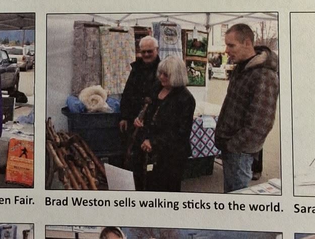 Newspaper photograph of Bradley Weston selling handmade walking sticks, captioned 'Brad Weston sells walking sticks to the world.'